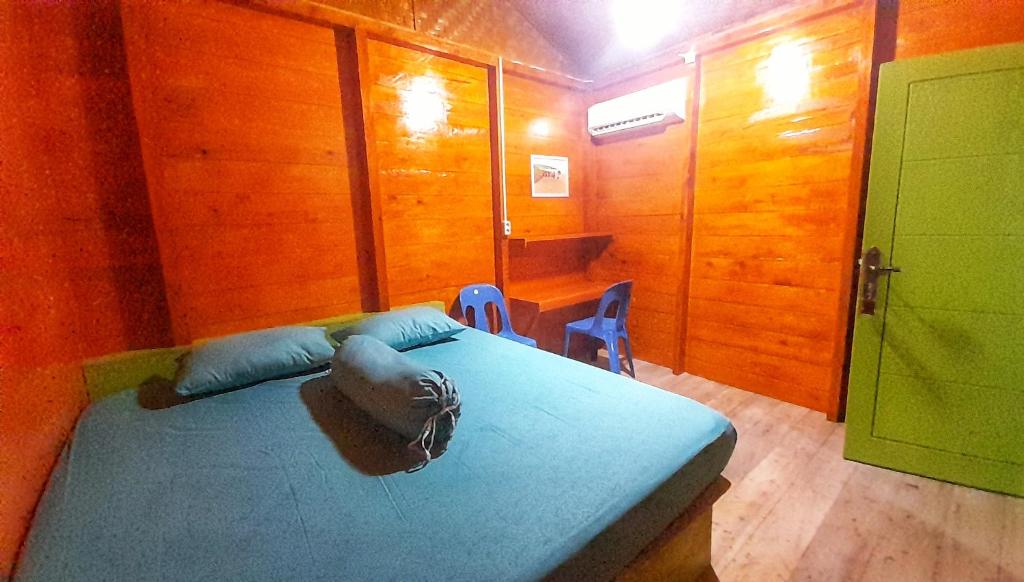 um quarto com uma cama, uma mesa e cadeiras em Gonias Hostel em Gunungsitoli
