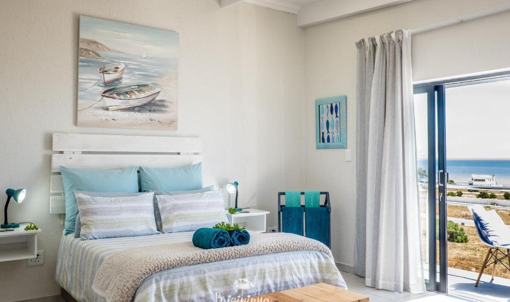 a bedroom with a bed with a view of the ocean at Forever Blue in St. Helena Bay