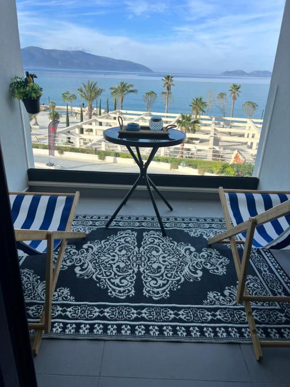 uma varanda com mesa e cadeiras e vista para o oceano em Sunset Resort em Vlorë