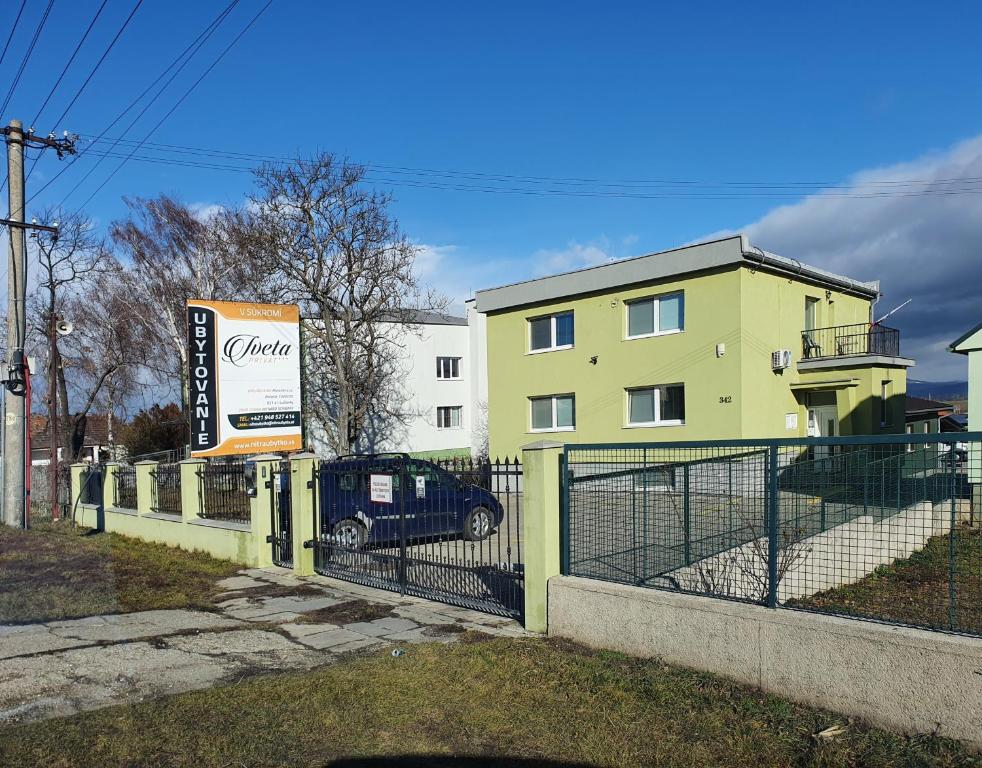 a sign in front of a building with a gate at UBYTOVANIE NITRA – Lužianky Privát Iveta in Šarlužky-Kajsa