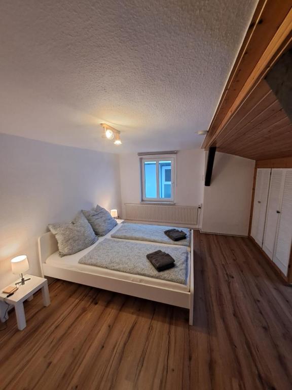a white bedroom with a bed and a window at Ferienwohnung Schulze in Hohenwestedt