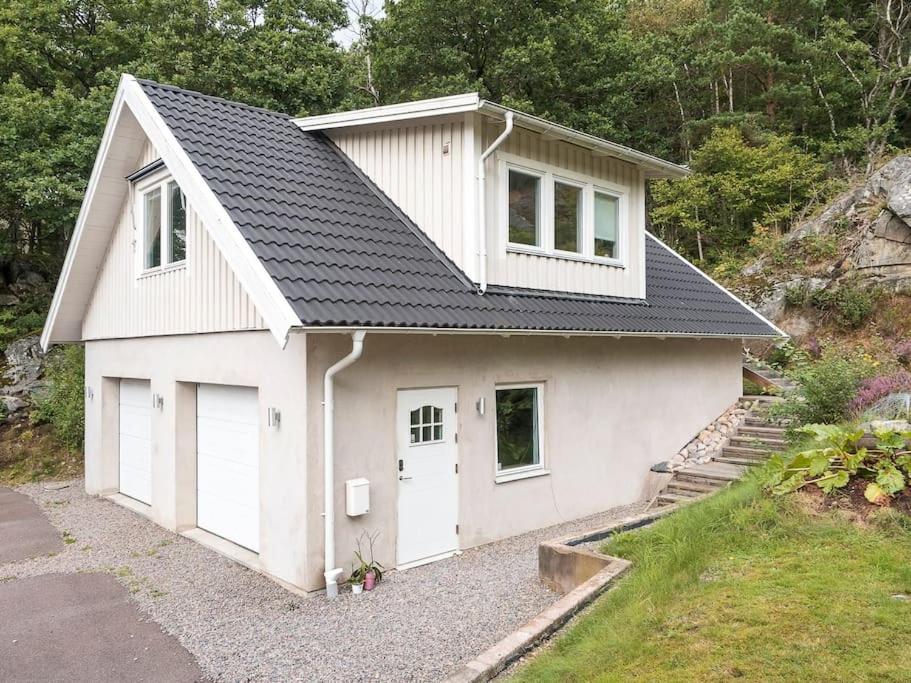 a white house with two garage doors in a driveway at A lovely bright apartment with it's own entrance in Kungsbacka