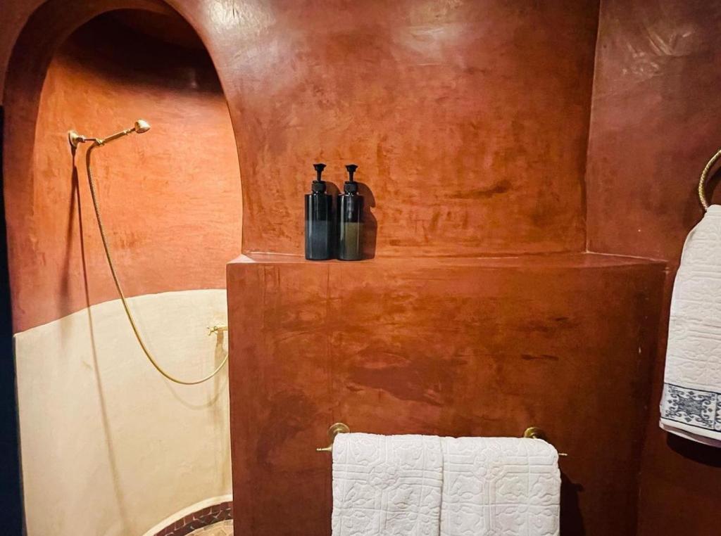 dos botellas de vino sentadas en un estante en un baño en Riad Bjoujna, en Marrakech