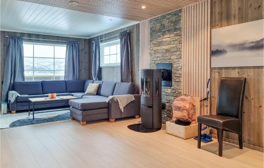 uma sala de estar com um sofá azul e uma cadeira em Amazing Home In seral With House A Mountain View em Åseral