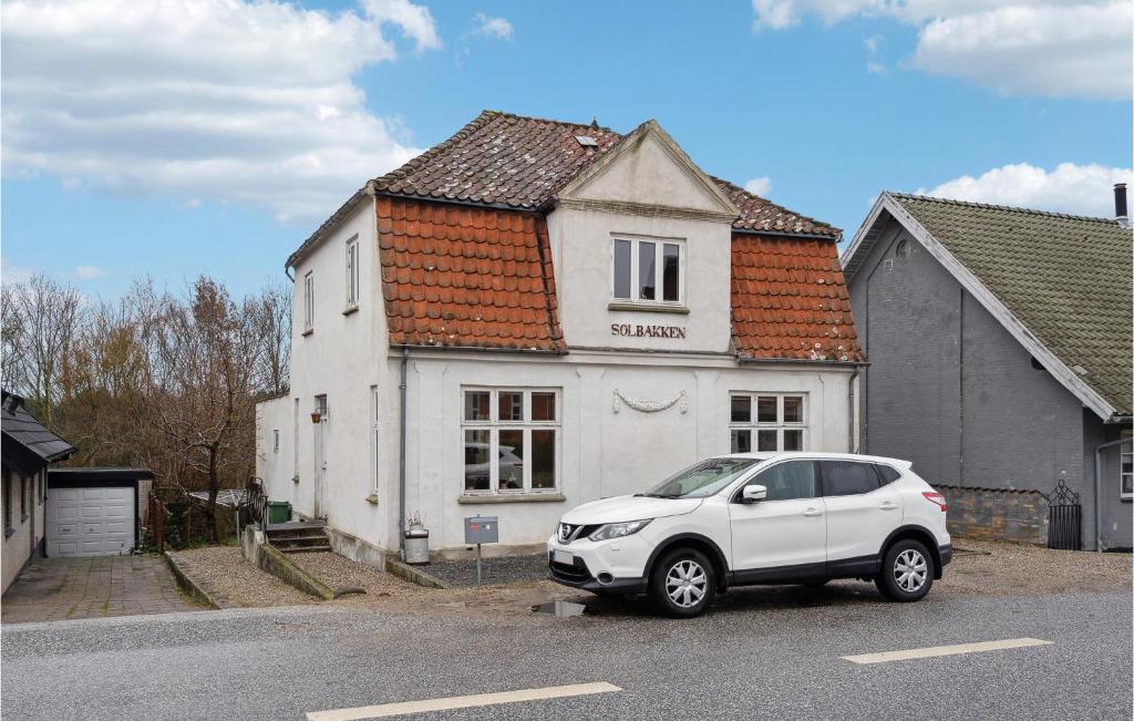 une voiture blanche garée devant une maison blanche dans l'établissement Nice Home In Faaborg With Wifi, à Fåborg