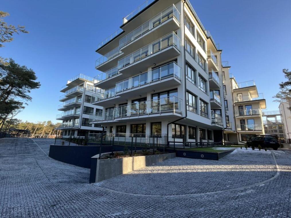 un grand immeuble d'appartements au milieu d'une rue dans l'établissement Apartament przy morzu W22, à Rowy