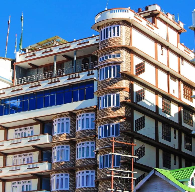 a tall white building with a spiral at Hotel Vivid Tawang in Tawang