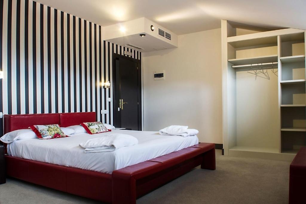 um quarto com uma cama grande e um banco vermelho em Hotel Teratermal em Valdeavellano de Tera