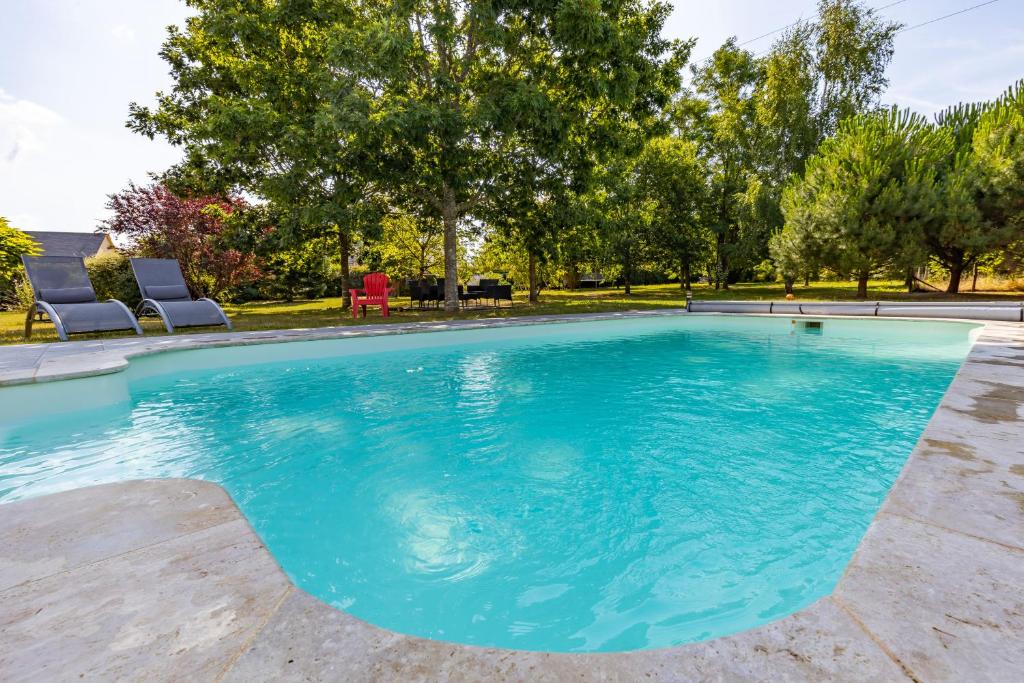 einen Pool mit blauem Wasser im Hof in der Unterkunft L'atelier des rêves, Maison avec Piscine privée in Meusnes