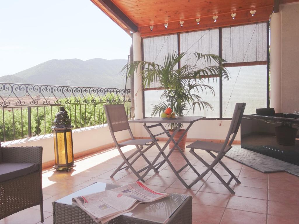 patio ze stołem i krzesłami oraz balkonem w obiekcie Studio Walla Confort Centre w mieście Montbrun-les-Bains