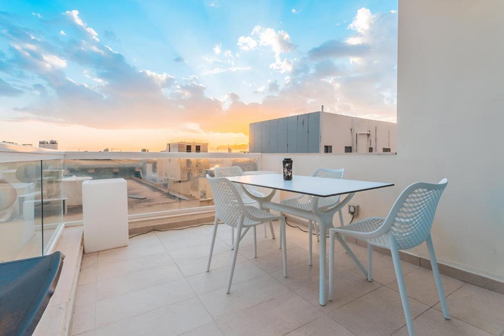 a patio with a table and chairs on a balcony at Chic Retreat in the Heart of Tigne Sliema in Sliema