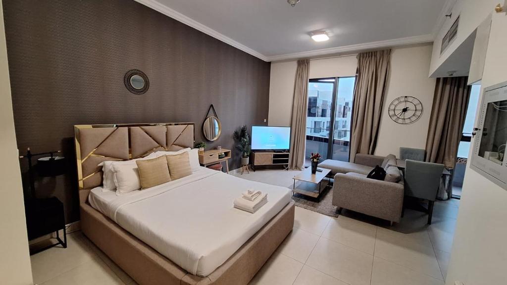 a bedroom with a large bed and a living room at Landing Lane Family Suites, Studio Near DXB Airport in Dubai