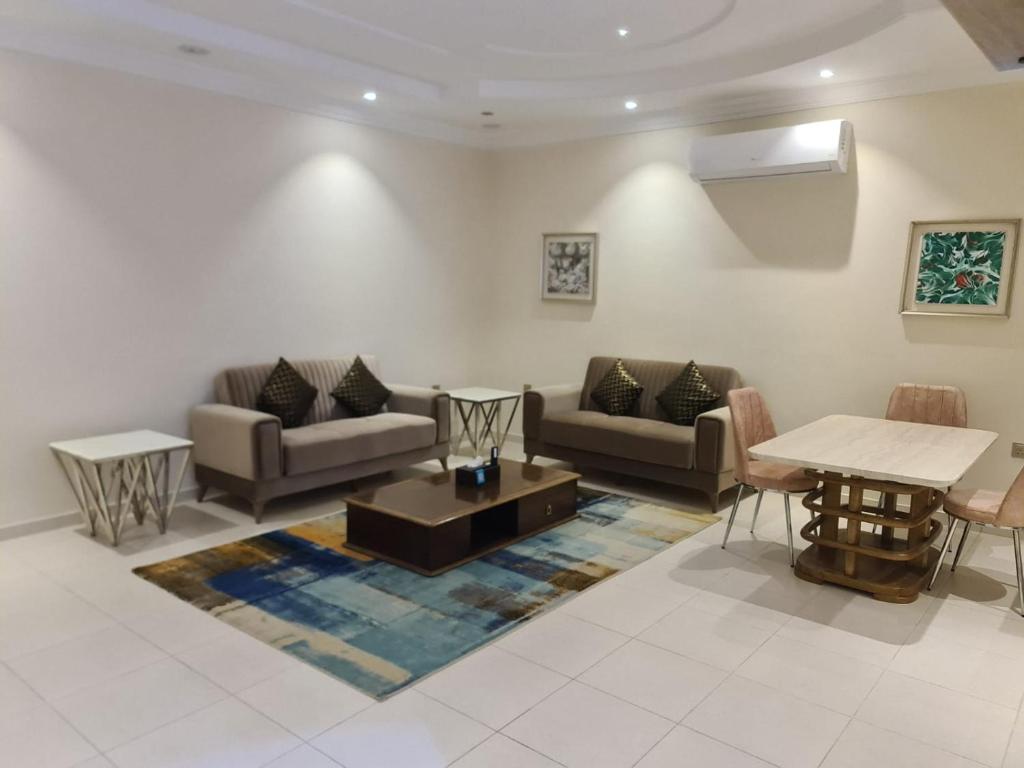 a living room with couches and a table at Dshale Apartments in Taif