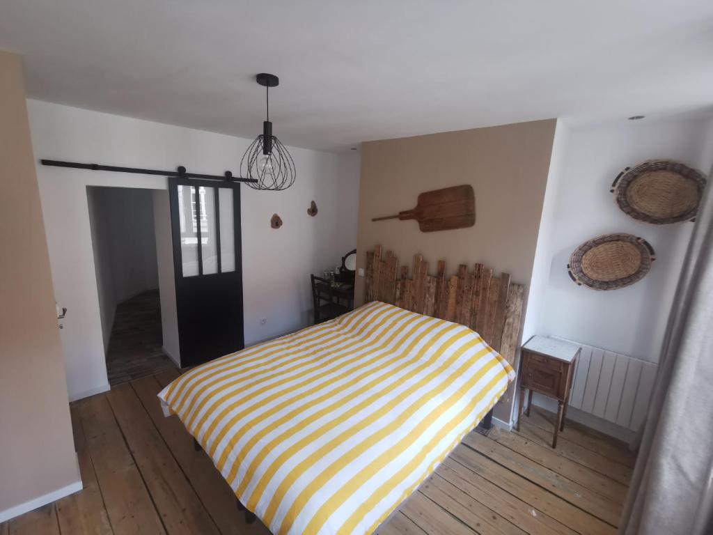 - une chambre avec un lit rayé jaune et blanc dans l'établissement La chambre de pousse, à Boulogne-sur-Mer