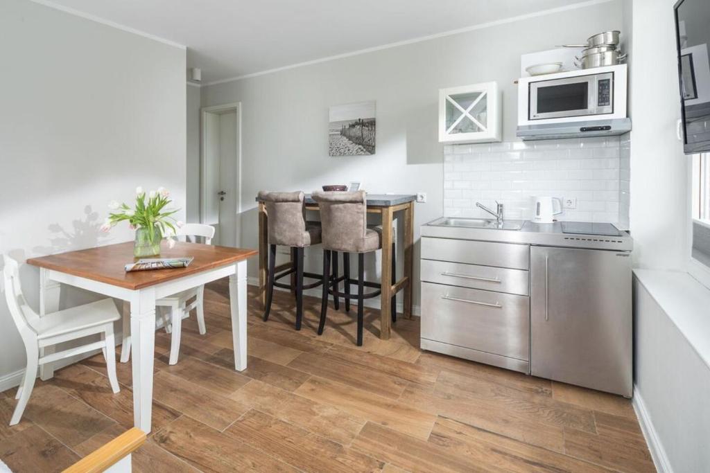 a kitchen and dining room with a table and a microwave at Haus Delft Agadir in Juist
