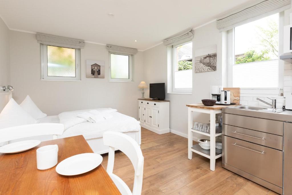 a kitchen and living room with a table and chairs at Haus Delft Jakea in Juist