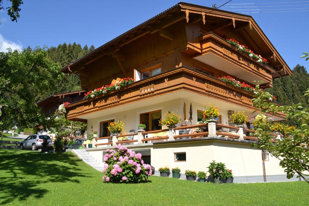 une maison avec des boîtes de fleurs sur le balcon dans l'établissement Haus Binder, à Ried im Zillertal