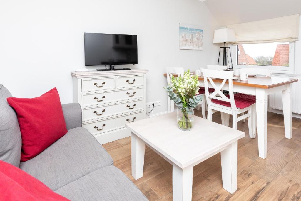 a living room with a couch and a table at Haus Delft Jaap Jacoba in Juist