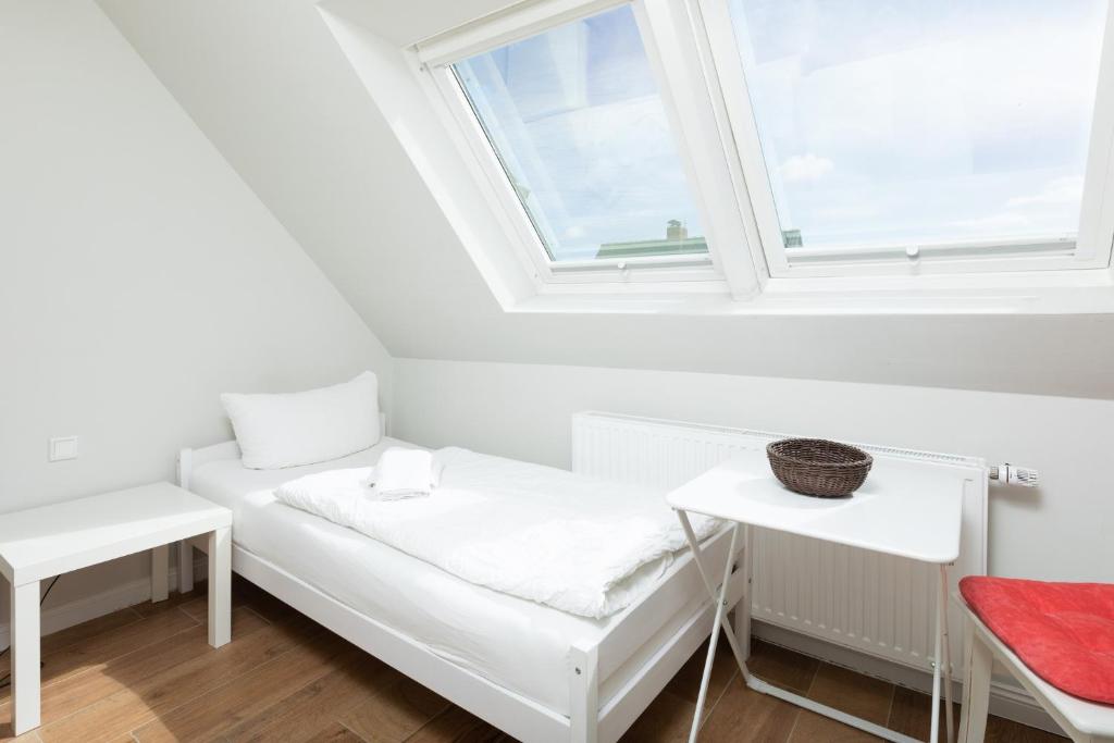 een witte kamer met een raam en een bank bij Haus Delft Ilmenau in Juist