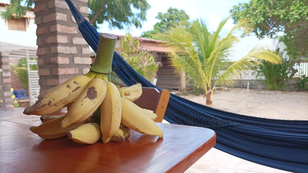 a bunch of bananas sitting on top of a wooden table at Chalés Peixes & Tartarugas in São Miguel do Gostoso