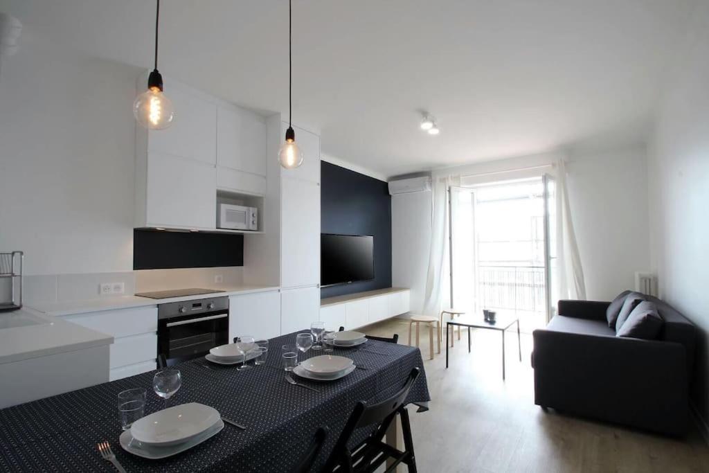 a kitchen and living room with a table and a couch at Magnifique 3 pièces Garibaldi in Nice