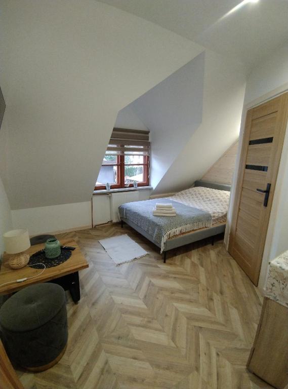 een slaapkamer met een bed en een houten vloer bij Pokoje Dębowa in Kazimierz Dolny