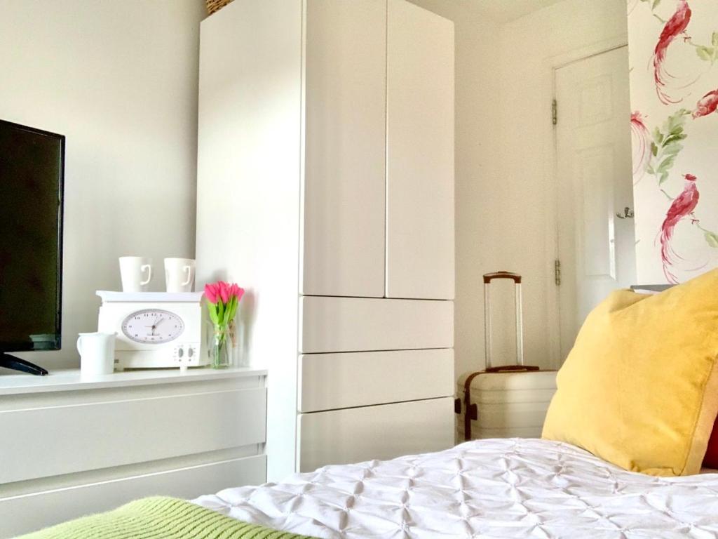 Un dormitorio con una cama y un reloj en un estante en 31 Churn Meadows Cirencester, en Stratton Saint Margaret