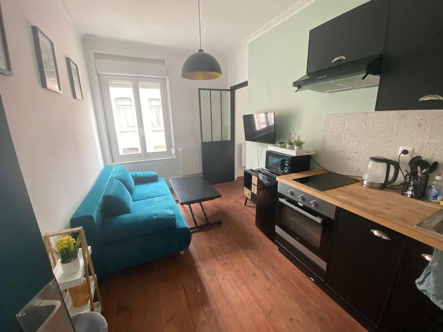 une cuisine avec une chaise bleue et une cuisinière dans l'établissement L'Escapade avec salle de sport, à Amiens