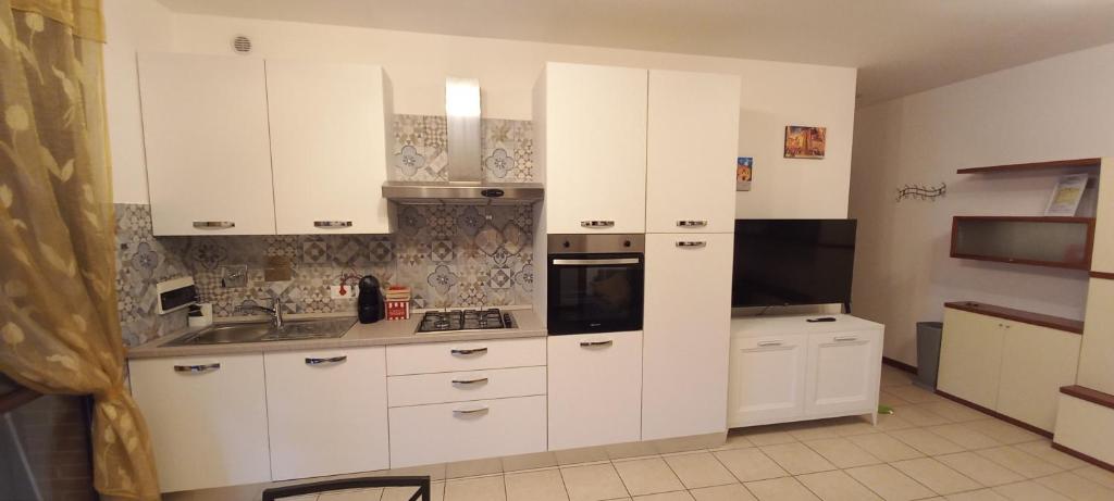 a kitchen with white cabinets and a sink at MIKY'S HOME in Castenaso