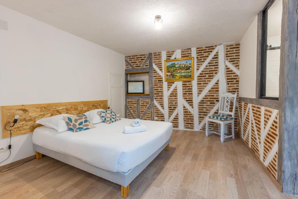 um quarto com uma cama branca e uma parede de madeira em Faune em Saint-Aignan