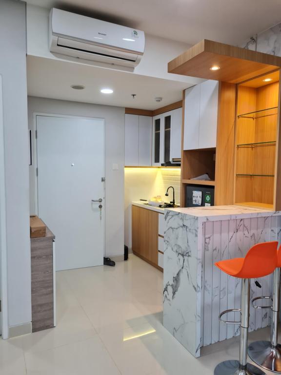 a kitchen with a counter and a red stool at Nuvasa Bay The Nove Kalani Tower in Telukmataikan