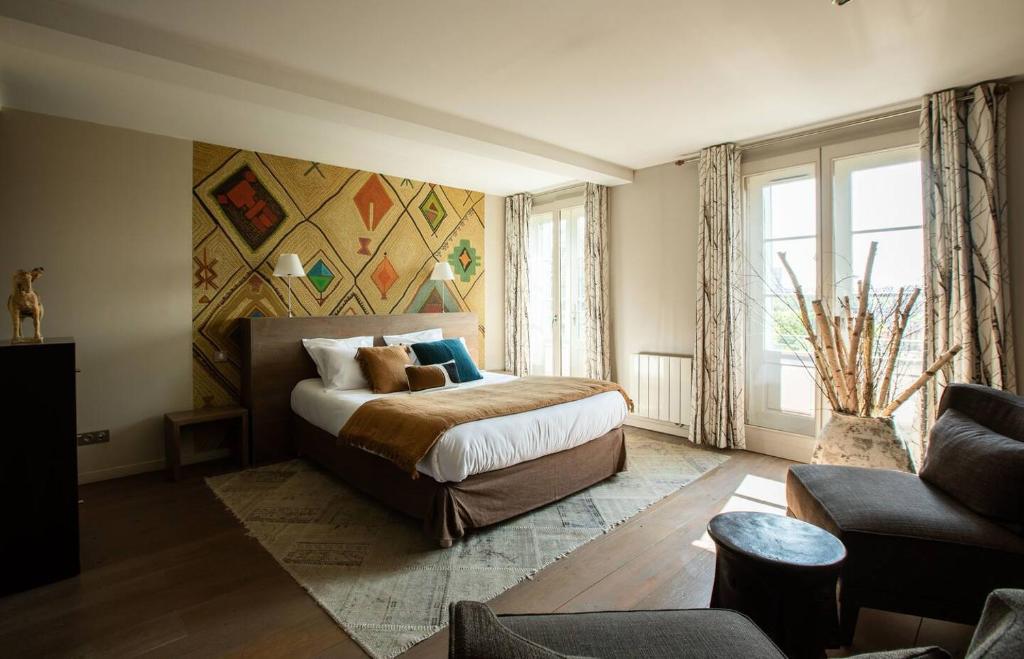 ein Schlafzimmer mit einem großen Bett und einem Sofa in der Unterkunft VILLA FLEURY - APPART'HÔTEL DE STANDING in Limoges