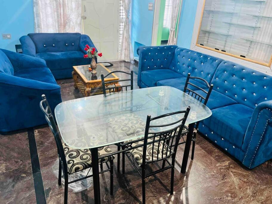 a living room with a blue couch and a table and chairs at Dreamy bungalow 2BHK apartment in Mysore