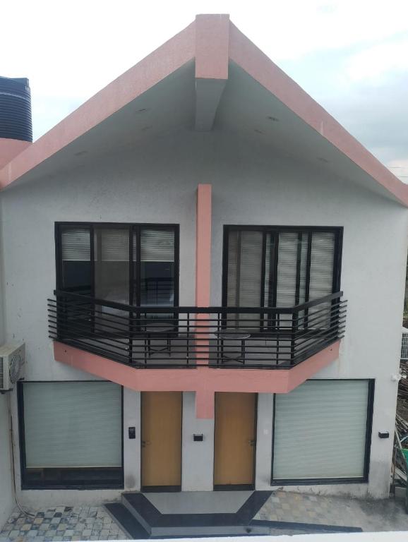 a house with a balcony on top of it at Suryaansh in Pālghar