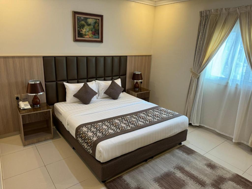 Postel nebo postele na pokoji v ubytování PRIMOTEL Suites As Salamah