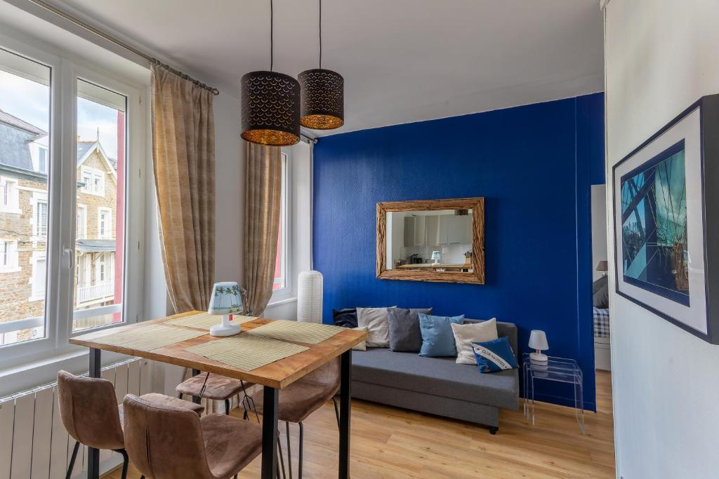 ein blaues Wohnzimmer mit einem Tisch und einem Sofa in der Unterkunft Appartement Saint-Malo - 10 mètres de la mer in Saint-Malo