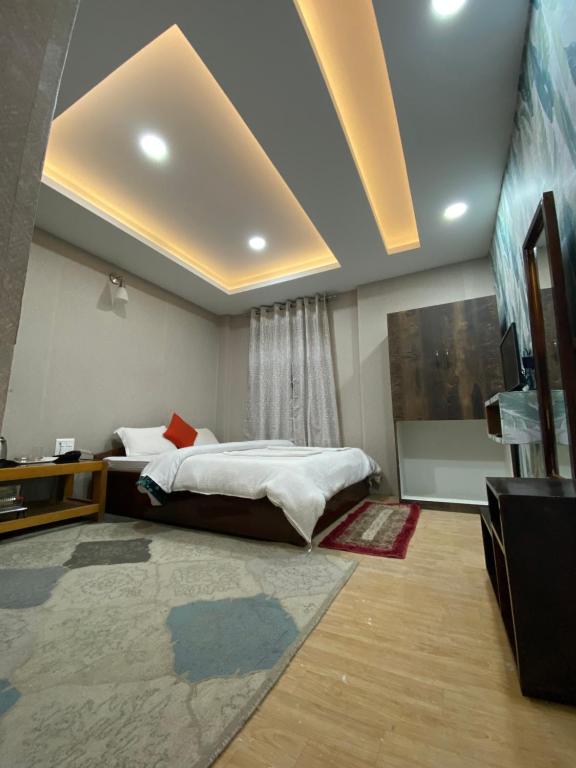 a bedroom with a bed and a television in it at Yul Pemakhar in Tawang