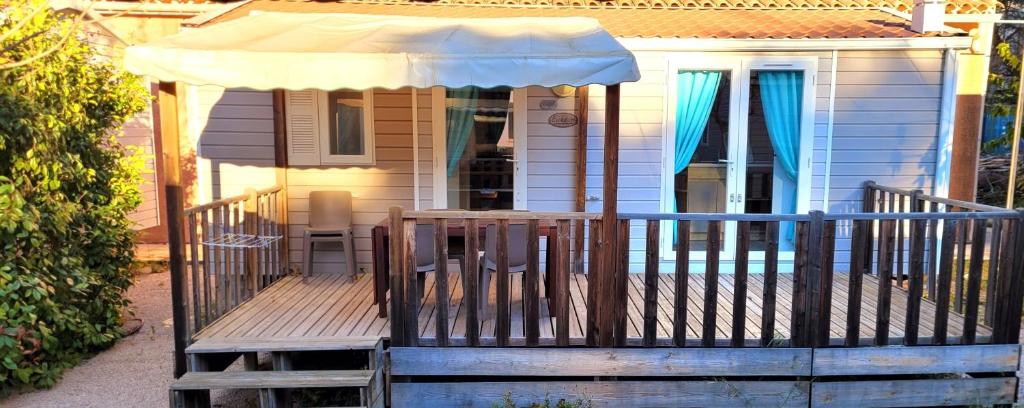 a wooden deck with an umbrella on a house at Camping Aux Portes De Cassis in La Bédoule