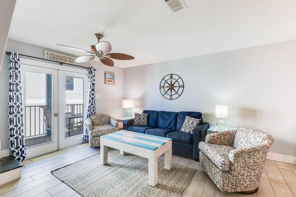 sala de estar con sofá azul y 2 sillas en Sundial C3 en Gulf Shores