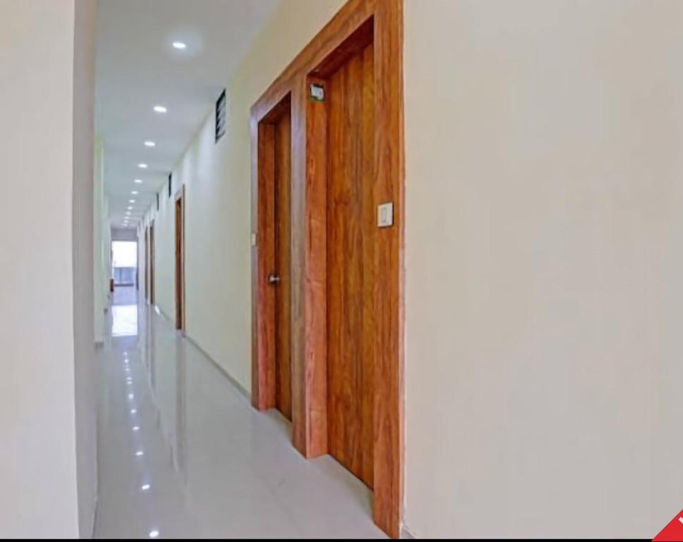 a corridor of a hospital with wooden doors at Hotel Rudrax - Anand in Anand