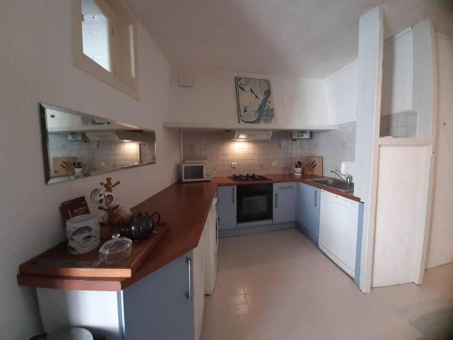 a kitchen with white cabinets and a wooden counter top at Maison de charme, plage a 300 m Dinard St Enogat in Dinard