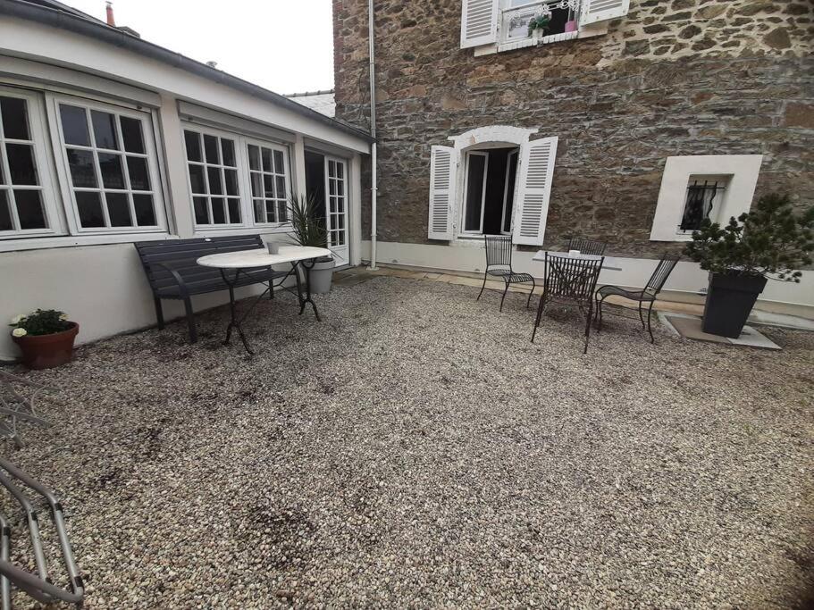 a patio with chairs and a table in front of a building at Maison de charme, plage a 300 m Dinard St Enogat in Dinard