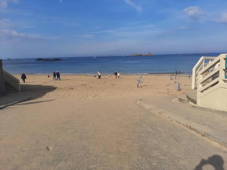a group of people on a beach near the ocean at Maison de charme, plage a 300 m Dinard St Enogat in Dinard