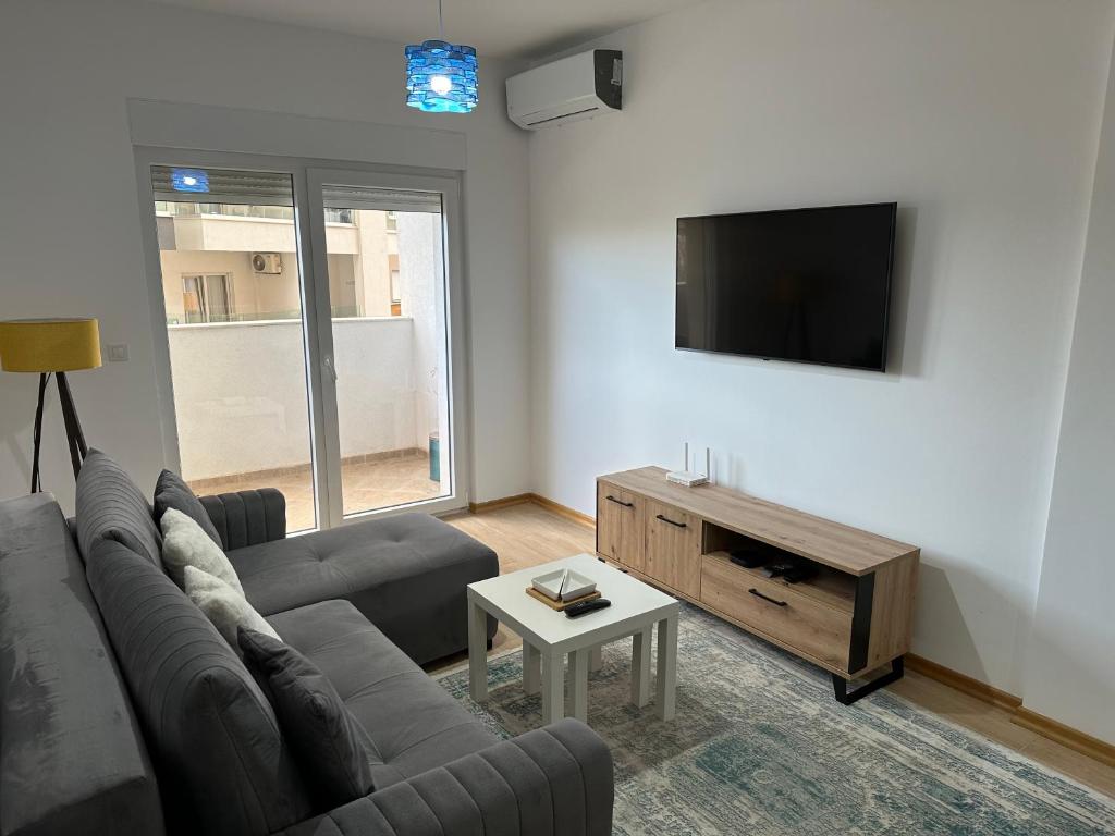 sala de estar con sofá y TV de pantalla plana en Apartment 06 en Budva