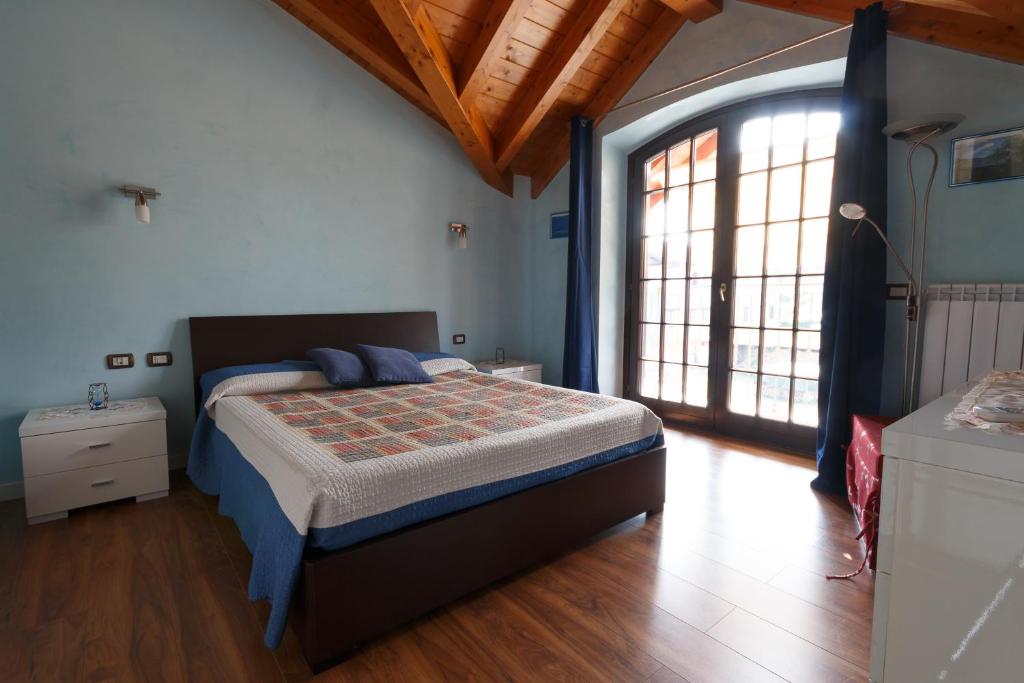 a bedroom with a bed and a large window at Il Gelsomino in Ferno