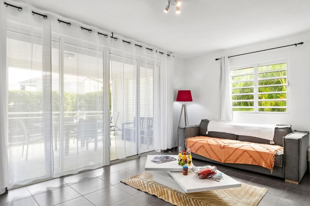 a bedroom with a bed and sliding glass doors at Le Cosmopolitain_ Appart 4/5p terrasse piscine in Cul de Sac