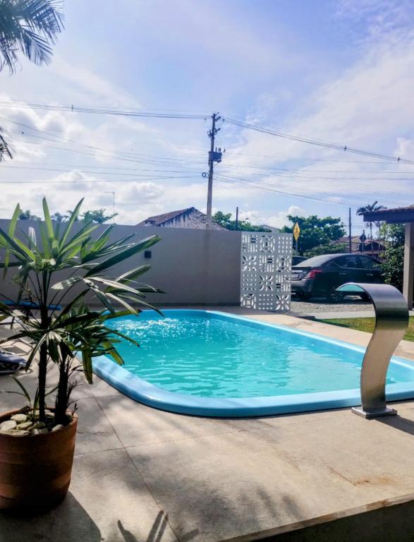 a swimming pool in a yard with a plant at Férias Perfeitas, Praia e Piscina in Itapoa