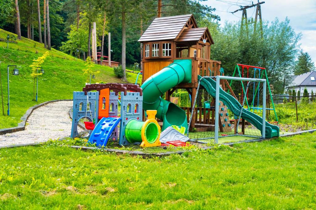 un parco giochi con scivolo e struttura per il gioco di Przystań nad Sanem z widokiem na góry i rzekę a Tyrawa Solna