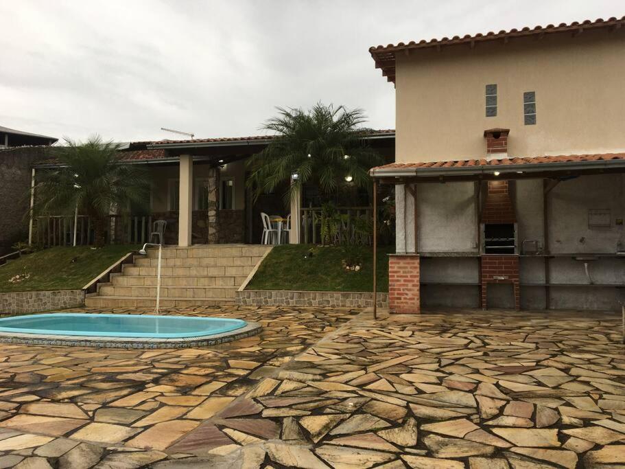 a house with a swimming pool in front of a house at Casa para temporada e hospedagem in Juiz de Fora