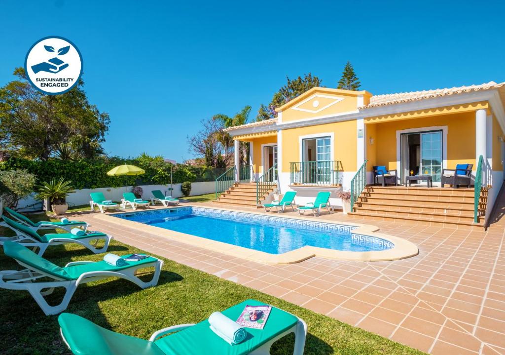 a villa with a swimming pool in front of a house at Villa Alegria in Albufeira